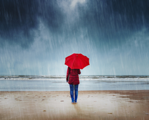 Woman on beach in the rain
